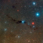 Vidvinkeloptagelse af den mørke sky Lupus 3 og tilhørende varme unge stjerner