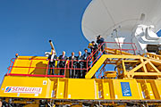Gasten bij de ALMA-inauguratie op een transportvoertuig