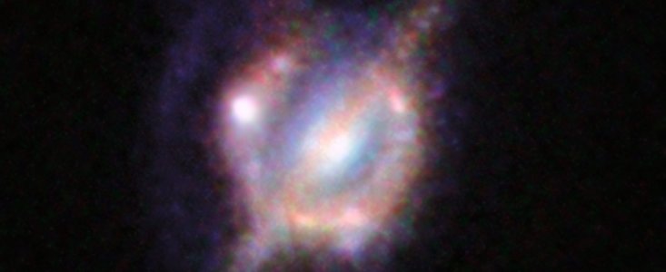 Kolliderande galaxer i det avlägsna universum sett genom ett kosmiskt förstoringsglas