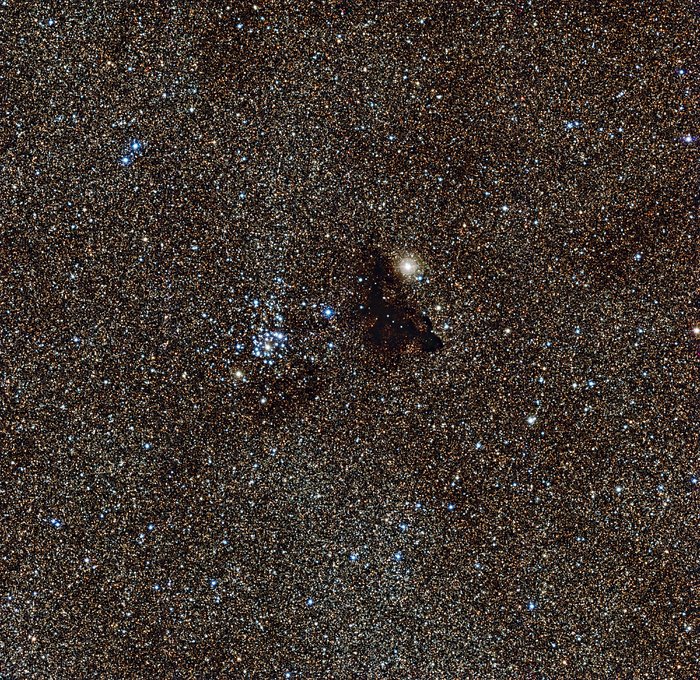 Der helle Sternhaufen NGC 6520 und die seltsam geformte Dunkelwolke Barnard 86